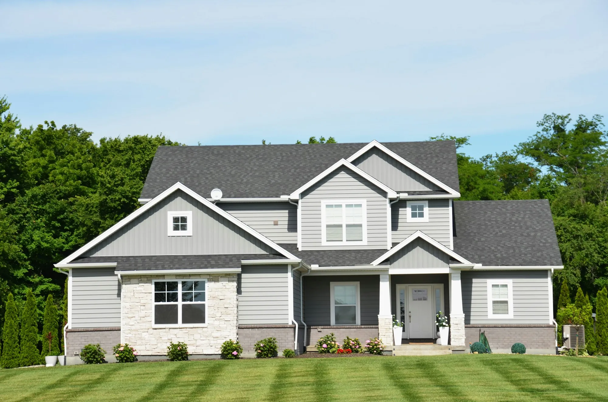 Gray two-story home with a striped front lawn